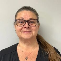 Smiling woman with glasses and ponytail.